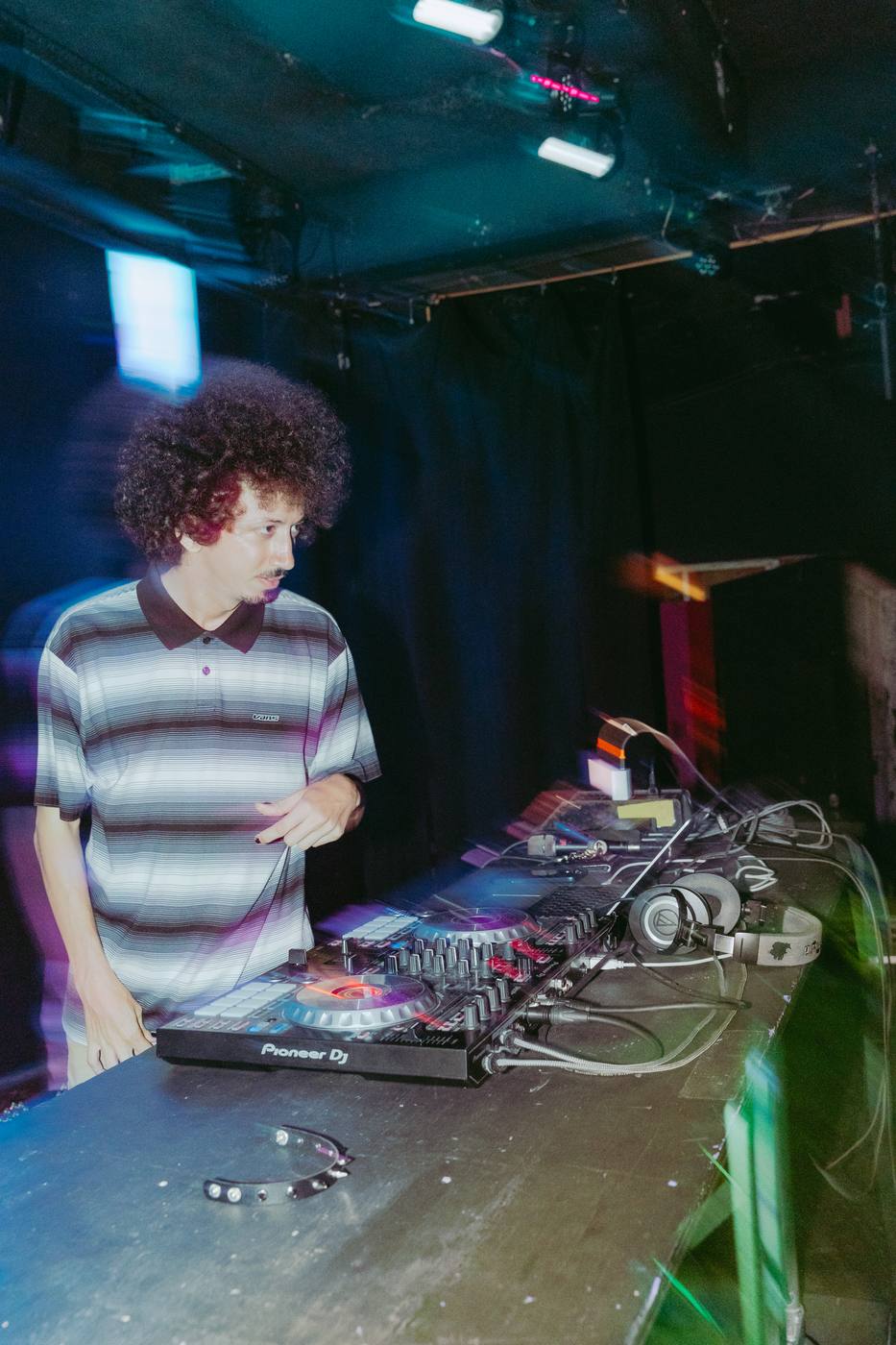 Bencore mixing at a DJ controller under blue light