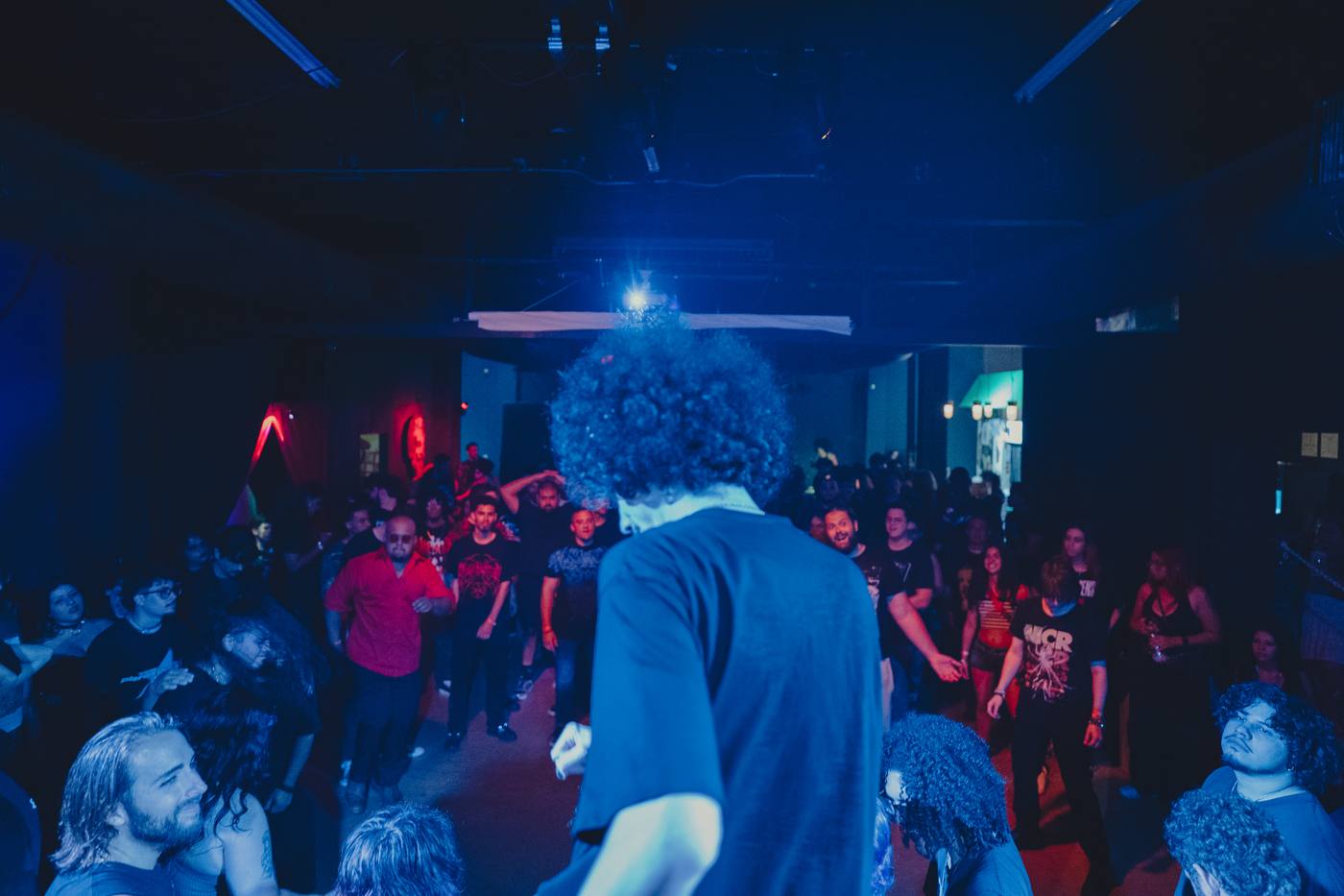 Bencore facing a crowd from the stage under blue light
