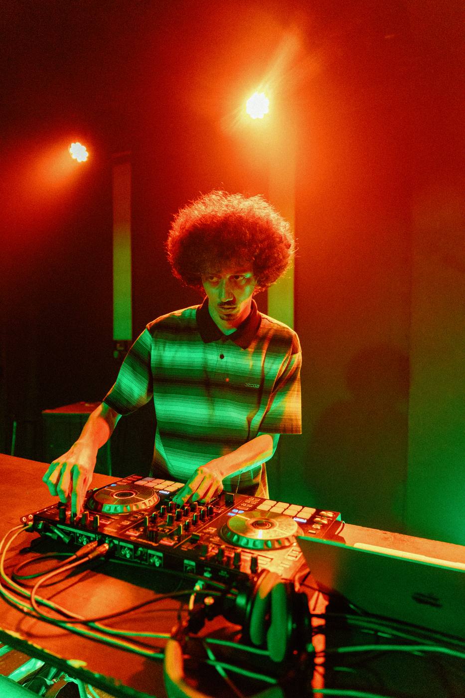 Bencore working the DJ controls under red and green light